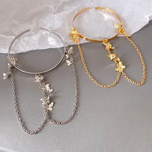 Gros plan de bracelets de bras papillon dorés et argentés avec chaînes délicates