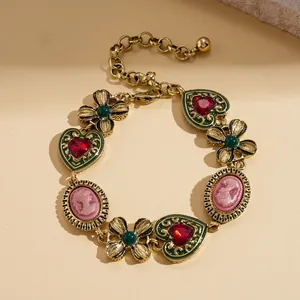 Vintage gold bracelet with red heart gems and pink cameo charms