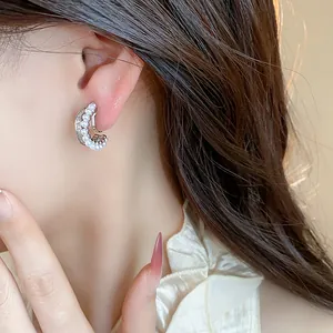 Macro view of an elegant French style C-shaped ear clip with pearls and zircons