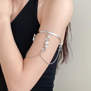 Détail du bracelet de bras à pampilles papillon en argent sur le bras, bijou élégant.