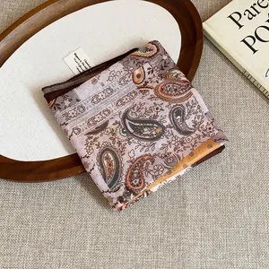 Detailed view of a vintage paisley print bandana on a rustic wooden tray background.