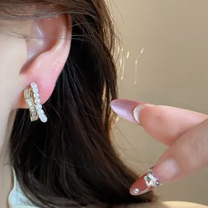 Close-up of elegant 18k gold plated pearl and zircon clip-on earring for women