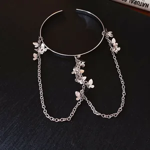 Vue détaillée de l'élégant bracelet de bras papillon argenté avec ses glands en chaîne.
