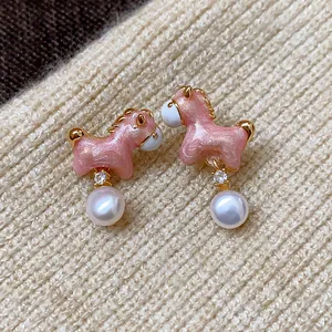 Primer plano de los pendientes de poni rosa brillante con circonita y colgante de perla.