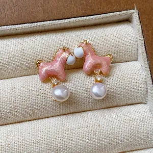 Detalle de pendientes de poni rosa con perlas y circón en joyero