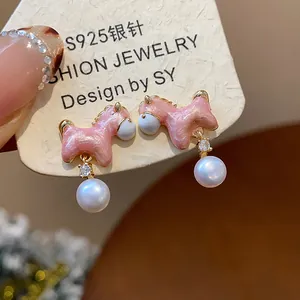 Detalle de pendientes de poni rosa con agujas de plata S925 y dijes de perlas colgantes