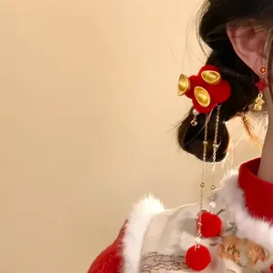 Gros plan d'une barrette en velours rouge avec lingots d'or et pompons de Nouvel An