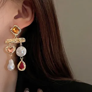 Elegant vintage style gold-toned dangle earrings with pearls, crystals, and heart charms