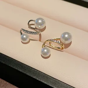 Detailed view of elegant gold and silver zircon pearl ear clips on velvet jewelry display