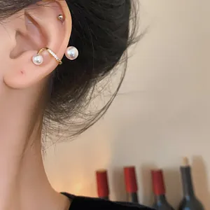 Close-up of gold-plated ear cuff with pearls and zircons for non-pierced ears.