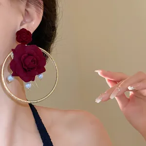Close-up of French vintage wine red rose earrings with pearls and golden hoops