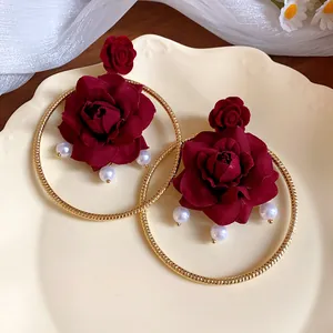 Detailed view of French vintage burgundy rose earrings with gold rings and pearls
