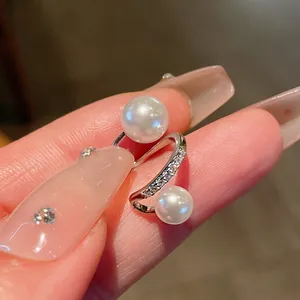 Detailed close-up of an elegant silver-plated ear cuff featuring double pearls and zircon stones.
