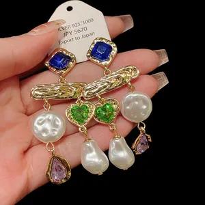 Detail showing vintage tassel earrings with pearls, green hearts, and blue crystals.
