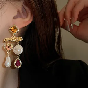 Close-up of vintage-style dangle earrings with pearls and multi-color rhinestones