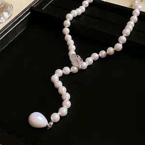 Detalle de un elegante collar de perlas de estilo francés con una hoja de circonitas