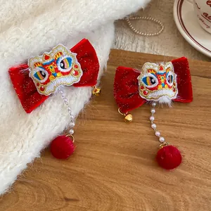 Gros plan de barrettes à nœud en velours rouge avec broderie traditionnelle de danse du lion