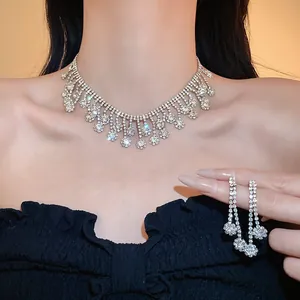 Detail shot of shimmering rhinestone tassel necklace and earrings set worn by a model