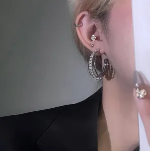 Detail shot of elegant silver hoop earrings with sparkling crystals on a model