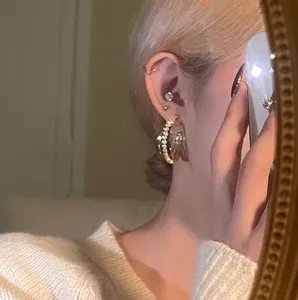 Close-up detail of elegant rhinestone oval fringe earrings worn by a model