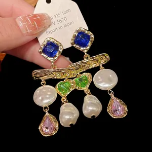 Detailed macro shot of vintage gold earrings with pearls and colorful crystals