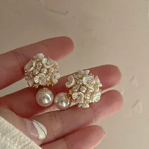Detailed macro shot of elegant floral pearl earrings with shimmering crystal accents.