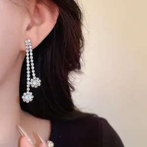 Close-up detail of elegant silver-tone rhinestone tassel drop earrings worn by a model