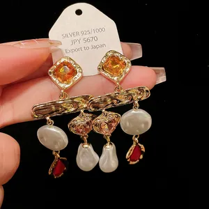 Detailed close-up of vintage gold tassel earrings with pearls and colored crystals