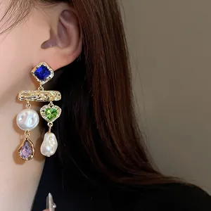 Close-up of vintage earrings with colorful rhinestones and baroque pearls