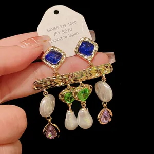 Detailed view of vintage gold-tone earrings featuring blue stones, pearls and heart charms
