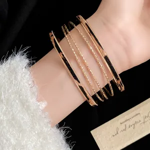 Close-up of leopard print leather bangle and gold textured bracelet set on elegant wrist