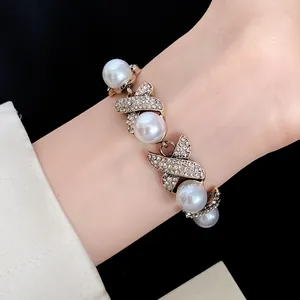 French vintage palace style bracelet featuring crossed rhinestone links and elegant pearls