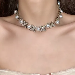 Detail view of a vintage French-style pearl and rhinestone choker necklace on a model