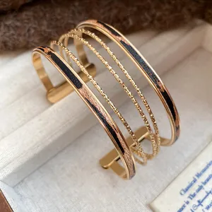 Detailed close-up of multi-strand gold cuff bracelet with trendy leopard print leather inlay