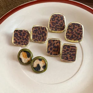 Gros plan de boucles d'oreilles rétro à imprimé léopard floqué de diverses formes.