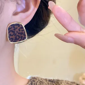 Gros plan d'une boucle d'oreille vintage en léopard floqué avec une bordure dorée