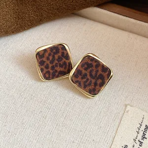 Gros plan de boucles d'oreilles léopard rétro avec monture en métal doré