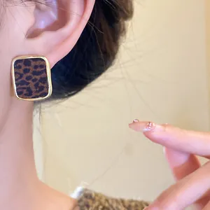 Gros plan d'une boucle d'oreille léopard rétro avec une élégante bordure dorée