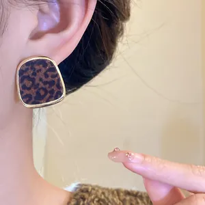 Gros plan d'une boucle d'oreille à imprimé léopard floqué avec bordure dorée