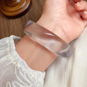 Detailed close-up of a transparent lavender acrylic bangle with an artistic marbling effect