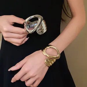 Macro detail of irregular geometric hollow open bangles in gold and silver tones