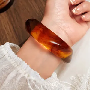 Macro view showing the vintage amber marbled texture of the irregular acrylic bangle