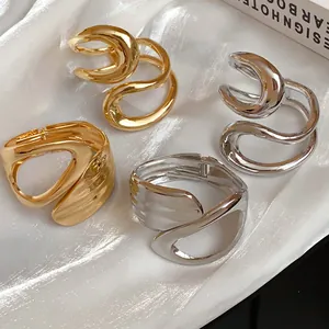 Detailed view of irregular geometric hollowed cross-open bracelets on white silk