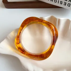 Detailed view of retro amber marbled acrylic bangle with irregular square shape.