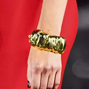 Detailed close-up showing the unique texture of an irregular wrinkled gold wide cuff bracelet