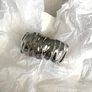 Detail shot of a minimalist silver irregular pleated wide cuff bracelet with polished finish