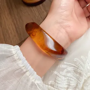 Amber acrylic marbled bangle with irregular shape shown on wrist for vintage style
