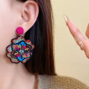 Macro view of vintage ethnic embroidered flower earring with colorful beads and crystal