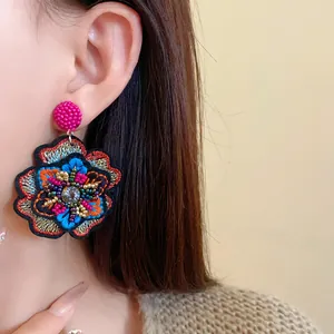 Detailed macro shot of vintage embroidered flower earring featuring colorful beads and rhinestones
