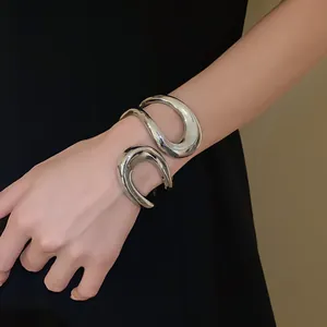 Detailed view of a silver irregular geometric open cuff bracelet on a female wrist